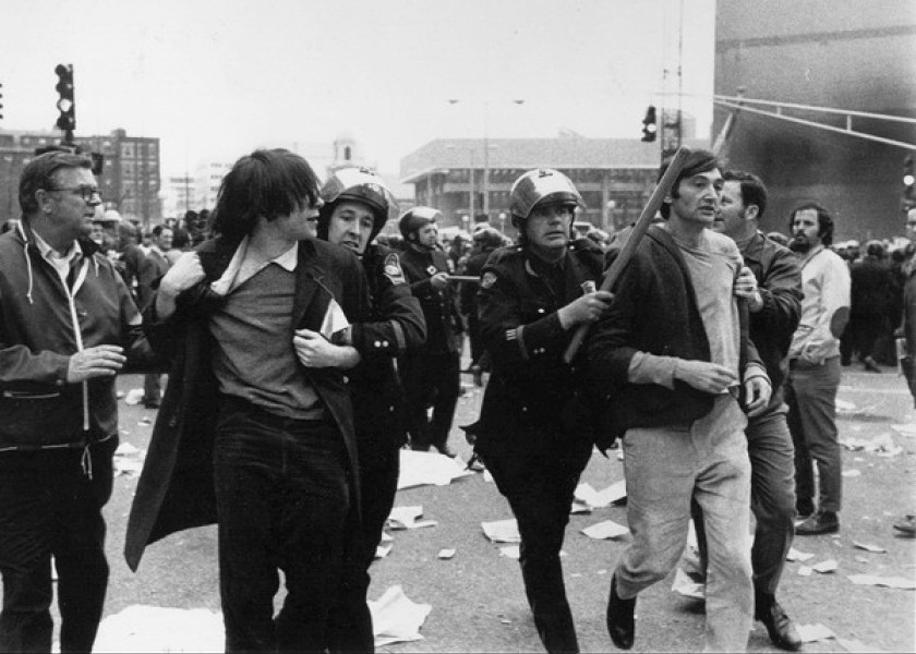 B&W photo of street scene, people arrested