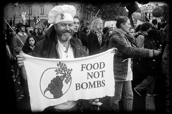 Black and white photo of man in chef hat and banner