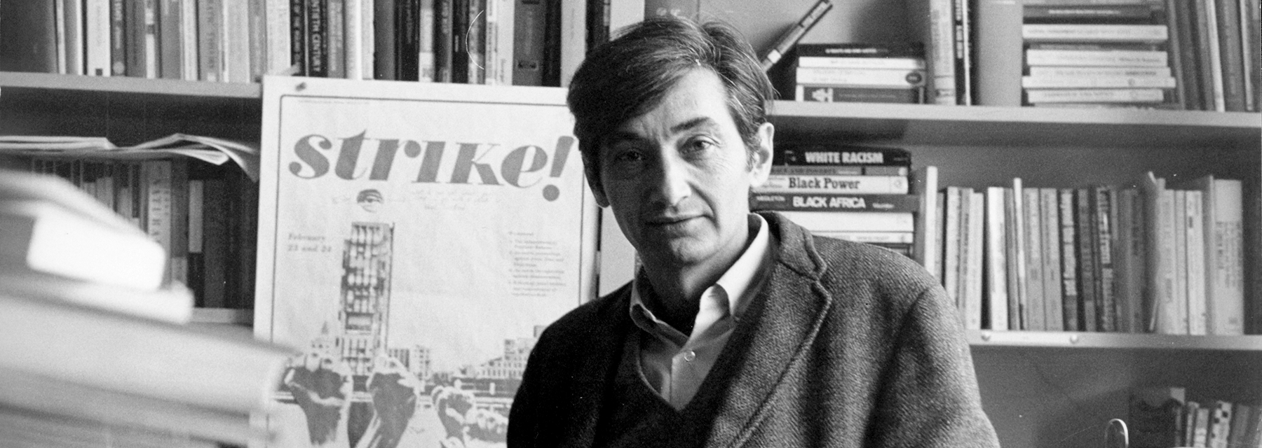 B&W photo of man, books, Strike poster