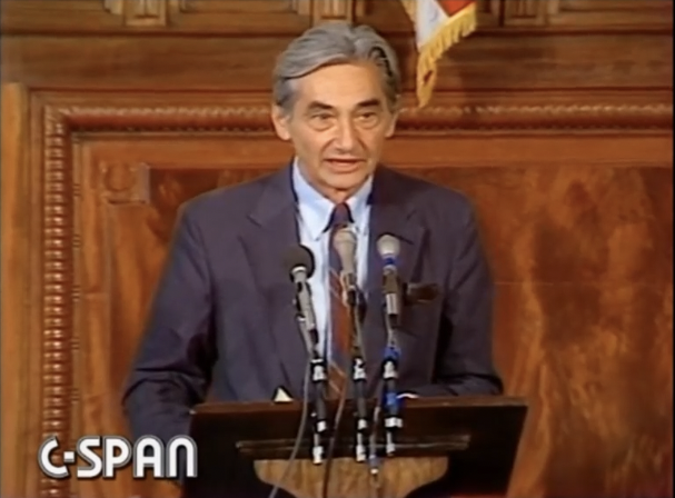 screenshot of man at podium